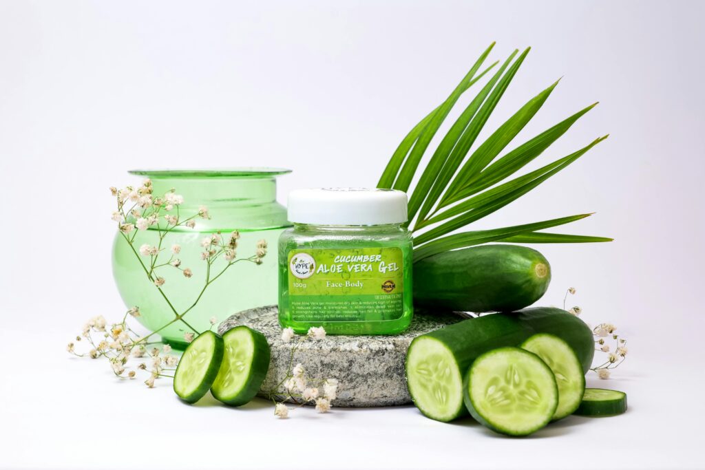 Aloe vera gel jar surrounded by cucumber slices, green accents, and white floral elements for a fresh aesthetic.