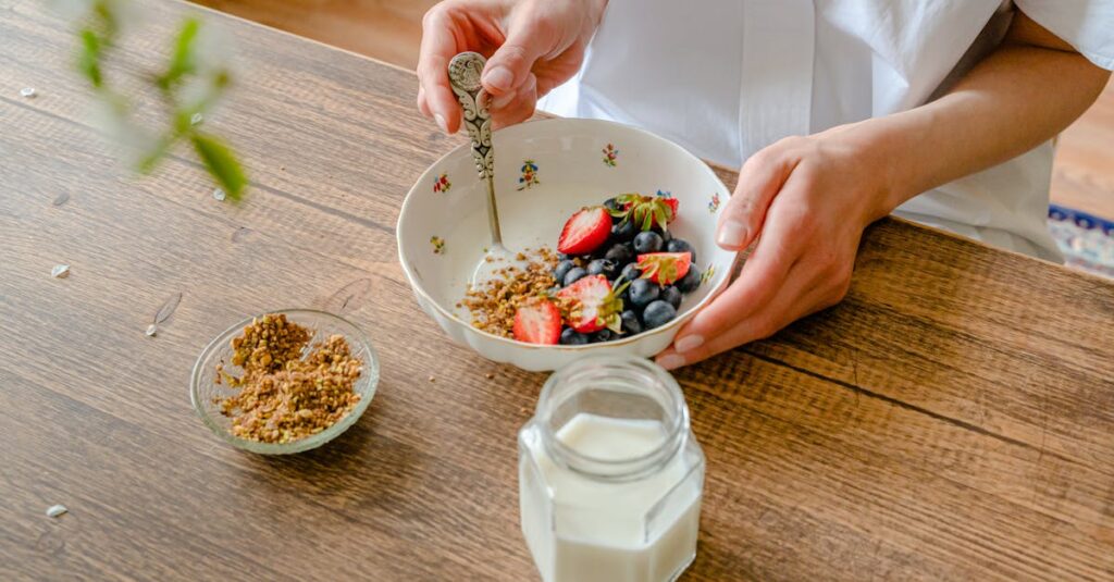 A vibrant homemade yogurt bowl with strawberries, blueberries, and crushed nuts, perfect for a healthy breakfast.