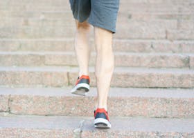 A person in athletic shoes climbing stone steps, showcasing determination and fitness.