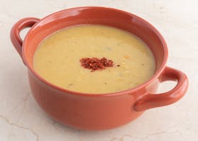 Delicious homemade lentil soup in a terra cotta bowl, perfect for a comforting meal.