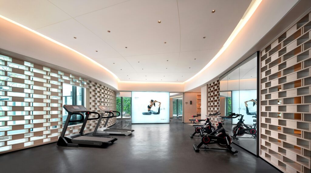 Sleek gym interior with treadmills and stationary bikes, technology-focused design.