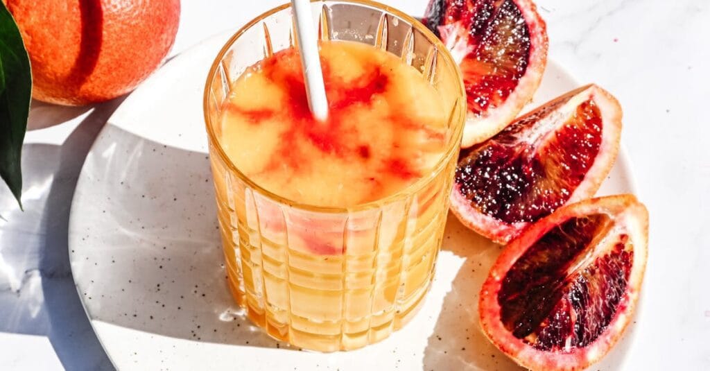 Bright and fresh blood orange juice in a glass, perfect for a sunny day.
