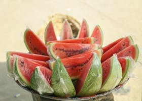A vibrant display of fresh watermelon slices wrapped in plastic, perfect for a refreshing snack.