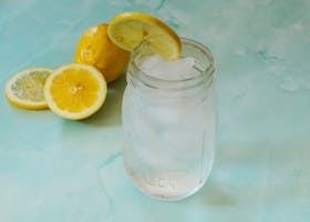 Chilled lemonade in a mason jar with lemon slices and ice cubes, perfect for summer.