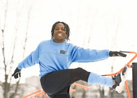 Energetic young athlete in blue warming up at an outdoor gym on a winter day.