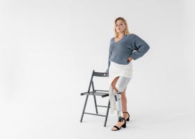 Caucasian woman standing confidently in a studio with a prosthetic leg, showcasing empowerment and modern prosthetics.